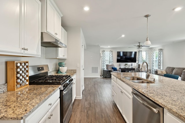 kitchen featuring a sink, under cabinet range hood, stainless steel appliances, and open floor plan