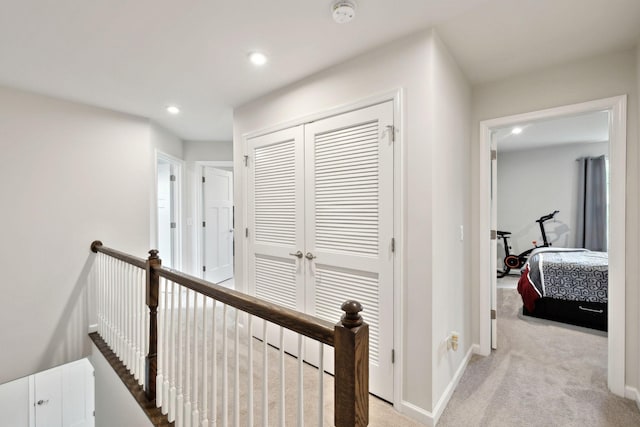 hall featuring recessed lighting, baseboards, an upstairs landing, and light carpet