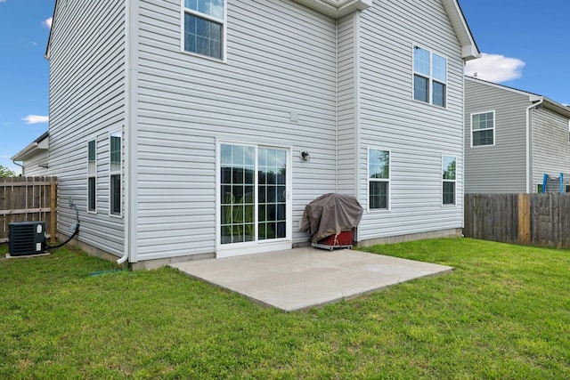 rear view of house featuring fence, a patio, a yard, and central AC
