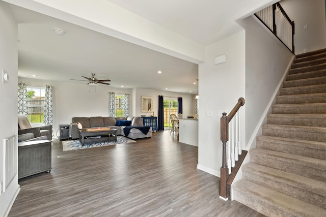 living room featuring stairs, wood finished floors, baseboards, ceiling fan, and recessed lighting