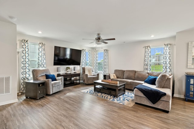 living room with recessed lighting, wood finished floors, and visible vents