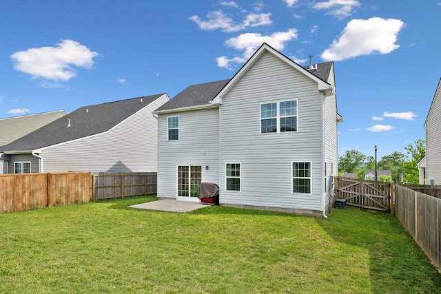 rear view of house featuring a fenced backyard, a lawn, and a patio area