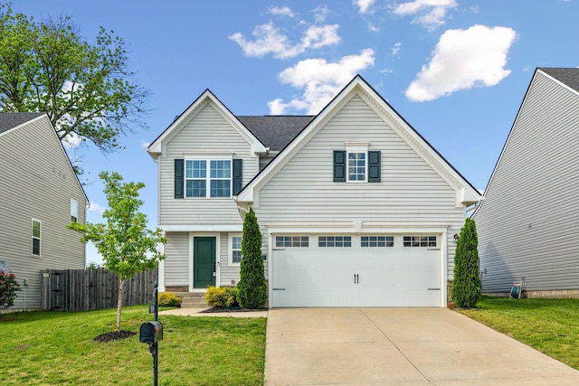 traditional home with fence, driveway, a front yard, and a garage
