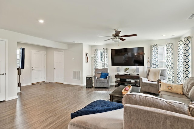 living area with baseboards, a ceiling fan, recessed lighting, and wood finished floors