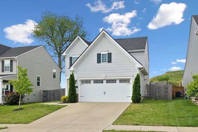 traditional home featuring a garage, fence, driveway, and a front yard