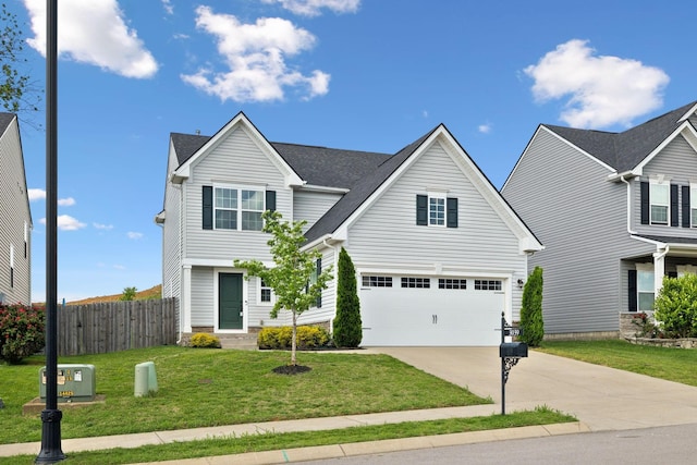traditional-style home featuring a garage, fence, driveway, and a front yard