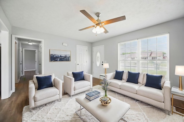 living room with baseboards, ceiling fan, and wood finished floors