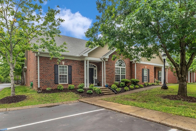 13 Hosier Ct, Lebanon, TN 37087 - view of front facade featuring brick siding, a front yard, uncovered parking, and roof with shingles