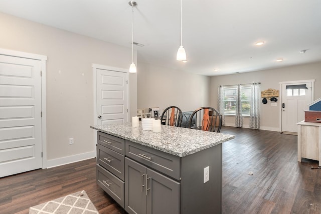 7025 Magnolia Crossings, Spring Hill, TN 37174 - kitchen featuring dark wood-style flooring, baseboards, gray cabinetry, a kitchen island, and light stone counters