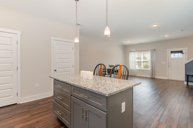 7025 Magnolia Crossings, Spring Hill, TN 37174 - kitchen with gray cabinets, dark wood-style flooring, hanging light fixtures, a kitchen island, and light stone countertops