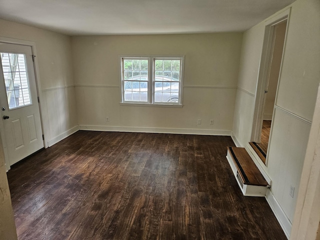 unfurnished room with baseboards and wood finished floors