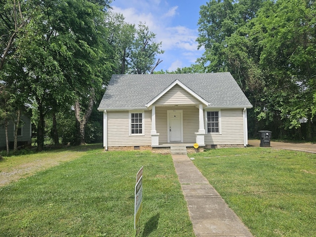 bungalow-style house featuring roof with shingles, covered porch, a front lawn, and crawl space