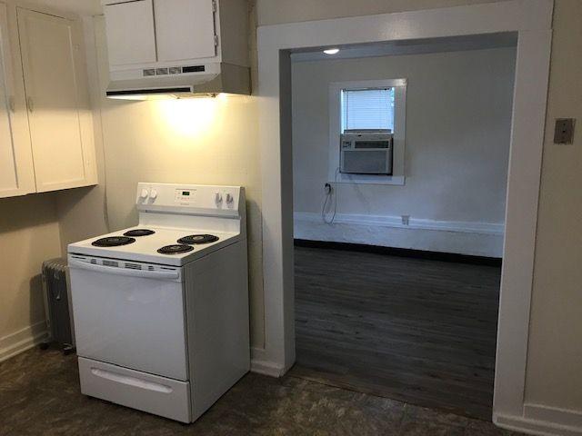 911 Leaf Ave, Murfreesboro, TN 37130 - kitchen with electric stove, under cabinet range hood, white cabinets, baseboards, and cooling unit