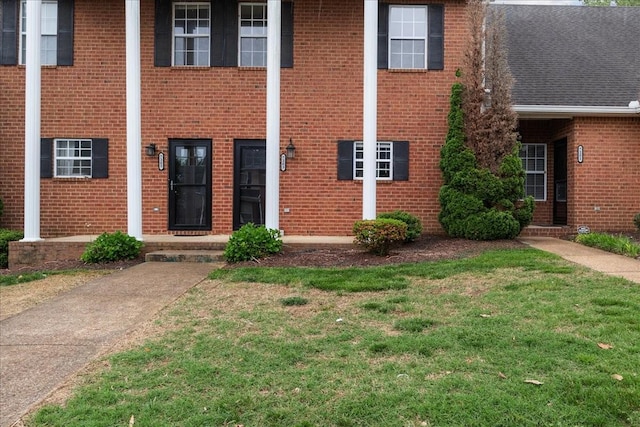 7203 Rosemary Ct, Fairview, TN 37062 - view of exterior entry with a lawn, brick siding, and roof with shingles