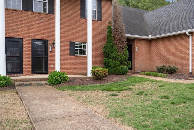 7203 Rosemary Ct, Fairview, TN 37062 - view of exterior entry with a yard, brick siding, and roof with shingles
