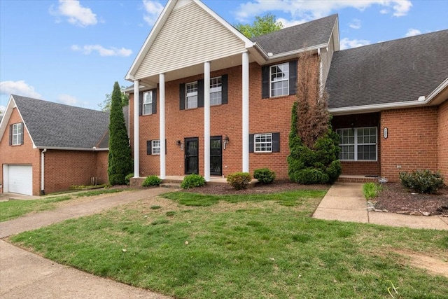 7203 Rosemary Ct, Fairview, TN 37062 - greek revival house featuring driveway, roof with shingles, a front yard, a garage, and brick siding