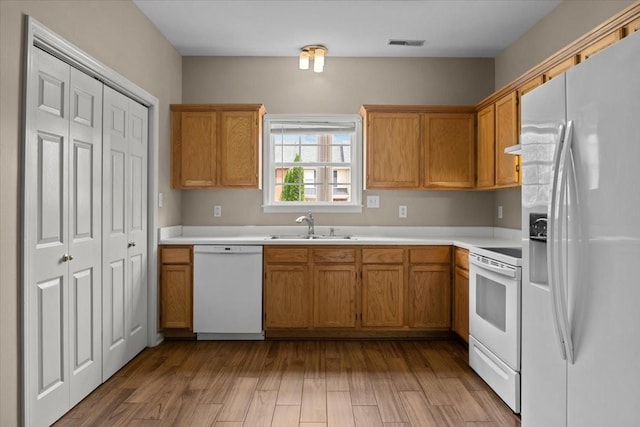 7203 Rosemary Ct, Fairview, TN 37062 - kitchen with visible vents, wood finished floors, a sink, light countertops, and white appliances