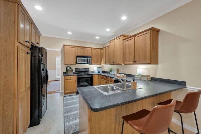 kitchen featuring dark countertops, a sink, black appliances, a peninsula, and recessed lighting