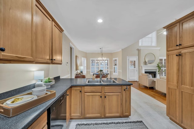 kitchen featuring an inviting chandelier, a sink, dishwasher, a large fireplace, and a peninsula