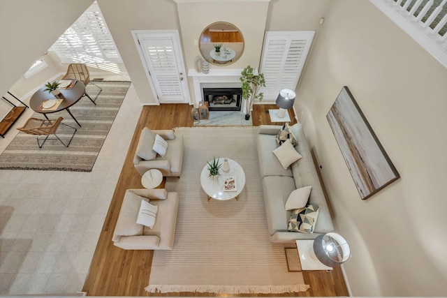 living area with baseboards, wood finished floors, and a fireplace