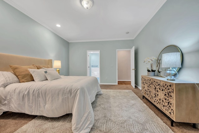 bedroom with carpet floors, ornamental molding, baseboards, and connected bathroom