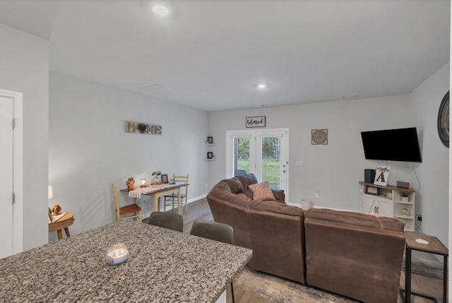 living room featuring baseboards, recessed lighting, and wood finished floors