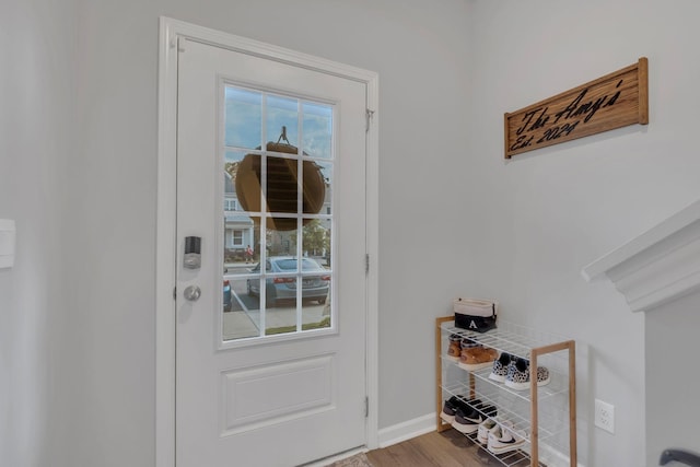 doorway with baseboards and wood finished floors