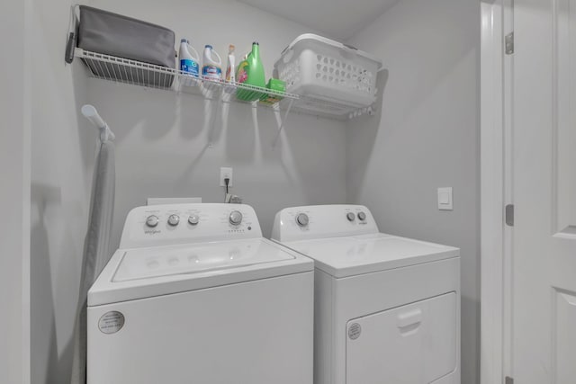 clothes washing area featuring laundry area and washer and clothes dryer