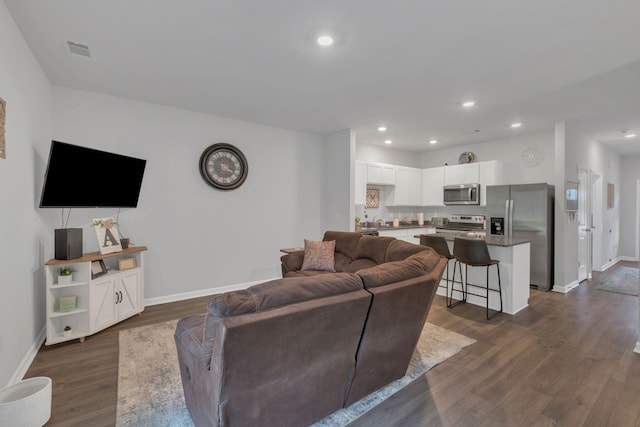 living area with visible vents, recessed lighting, dark wood finished floors, and baseboards