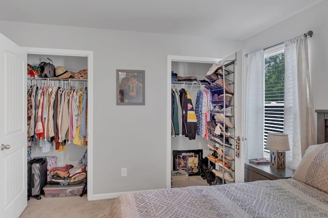 carpeted bedroom featuring baseboards, a spacious closet, and a closet