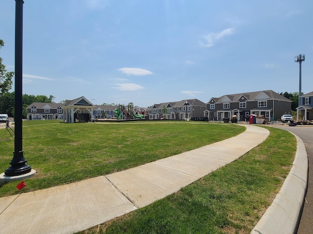view of home's community featuring a lawn, playground community, and a residential view