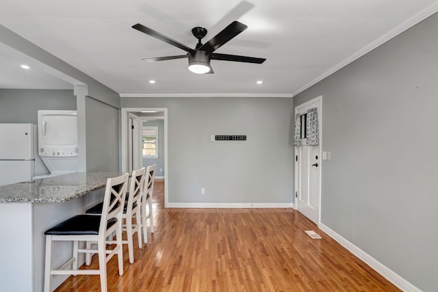 307 Franklin St, Cowan, TN 37318 - unfurnished dining area with stacked washer / drying machine, a ceiling fan, light wood-style floors, ornamental molding, and baseboards