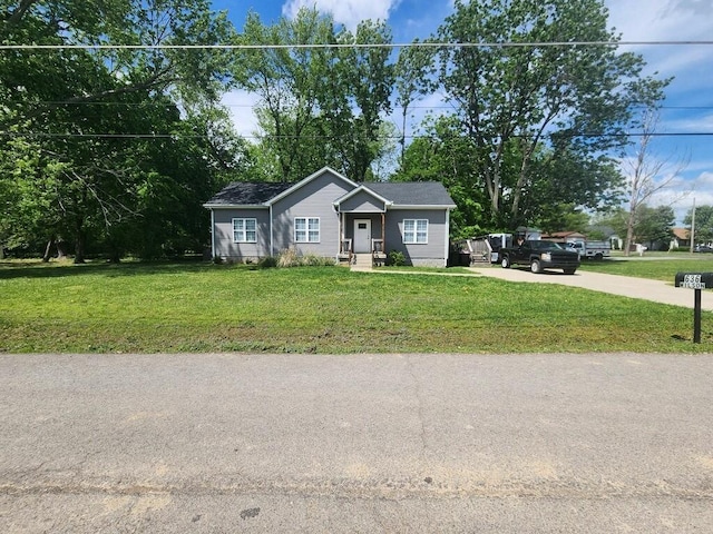 view of front of house featuring concrete driveway and a front yard