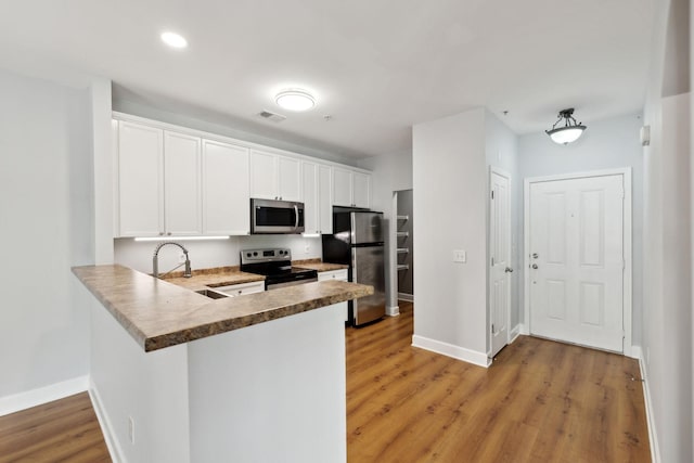 8231 Lenox Creekside Dr Unit C7, Antioch, TN 37013 - kitchen featuring stainless steel appliances, light wood-style flooring, baseboards, white cabinetry, and recessed lighting