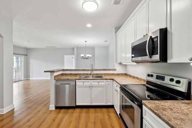 8231 Lenox Creekside Dr Unit C7, Antioch, TN 37013 - kitchen featuring appliances with stainless steel finishes, a sink, light wood-type flooring, white cabinets, and a peninsula