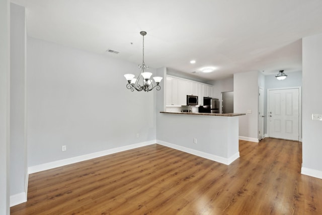 8231 Lenox Creekside Dr Unit C7, Antioch, TN 37013 - kitchen featuring stainless steel appliances, white cabinetry, wood finished floors, baseboards, and a peninsula