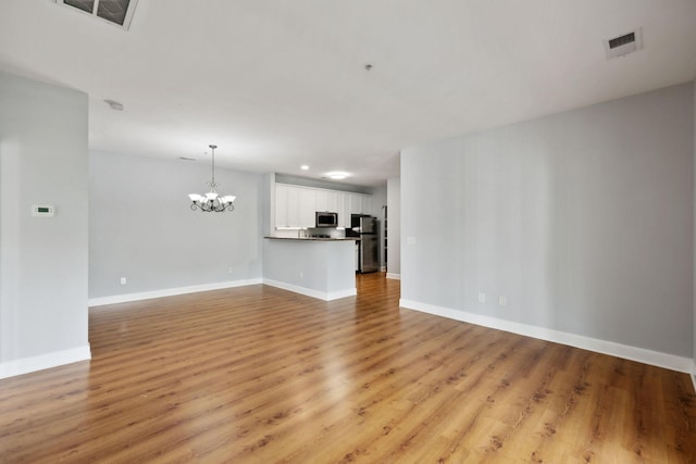 8231 Lenox Creekside Dr Unit C7, Antioch, TN 37013 - unfurnished living room with a chandelier, light wood finished floors, and baseboards