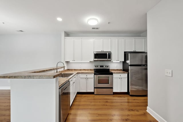 8231 Lenox Creekside Dr Unit C7, Antioch, TN 37013 - kitchen featuring appliances with stainless steel finishes, a sink, a peninsula, white cabinets, and recessed lighting