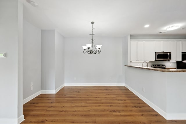 8231 Lenox Creekside Dr Unit C7, Antioch, TN 37013 - kitchen featuring stainless steel appliances, a chandelier, white cabinets, wood finished floors, and a sink