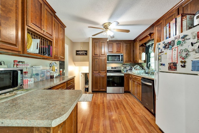 286 Pine Grove Rd, South Pittsburg, TN 37380 - kitchen featuring brown cabinetry, a ceiling fan, light wood finished floors, and stainless steel appliances