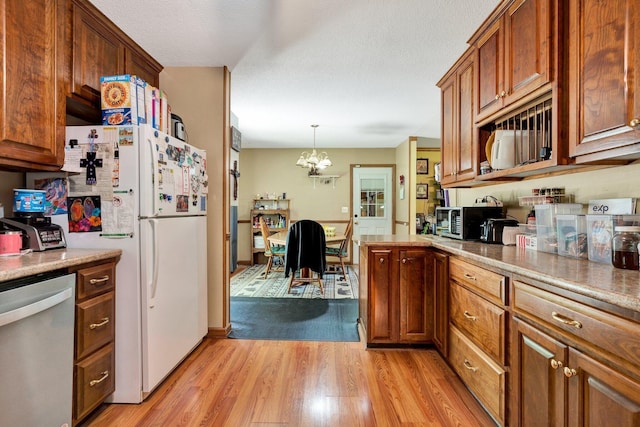 286 Pine Grove Rd, South Pittsburg, TN 37380 - kitchen with stainless steel dishwasher, freestanding refrigerator, light wood-style flooring, and brown cabinetry