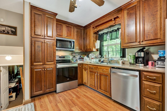 286 Pine Grove Rd, South Pittsburg, TN 37380 - kitchen featuring a sink, appliances with stainless steel finishes, brown cabinetry, and light wood finished floors
