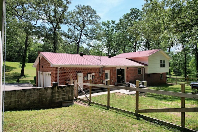 286 Pine Grove Rd, South Pittsburg, TN 37380 - back of house with metal roof, a lawn, brick siding, fence, and an attached garage