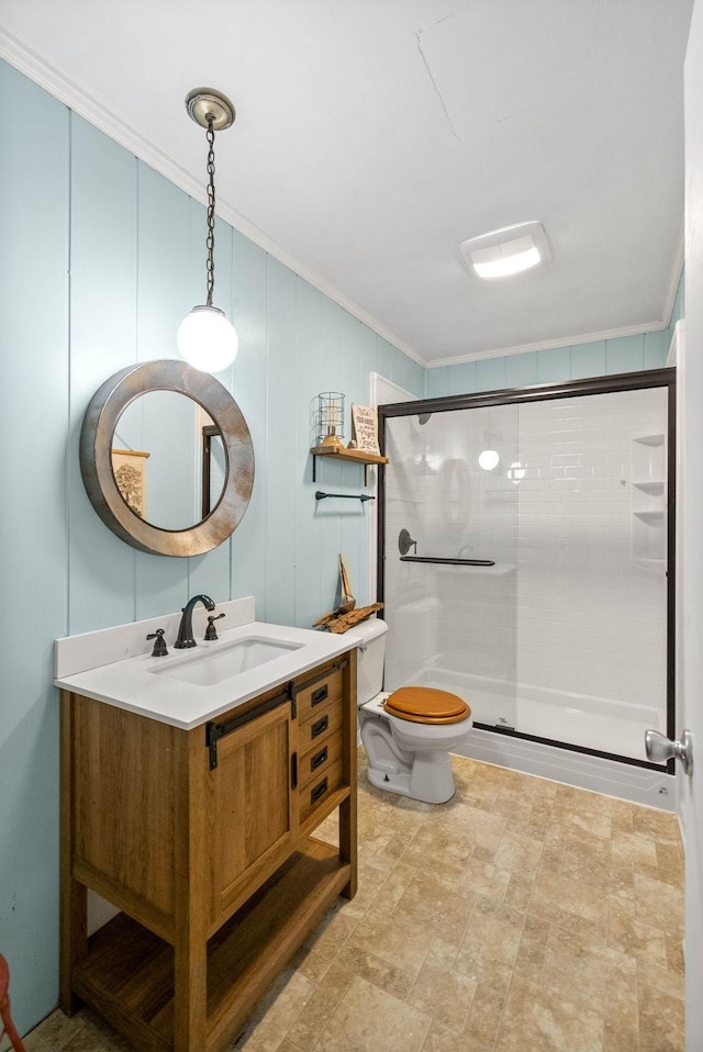 full bathroom with crown molding, toilet, a shower stall, and vanity