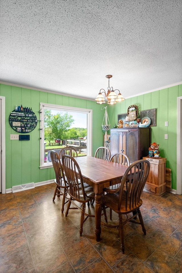 dining area with a textured ceiling and a chandelier