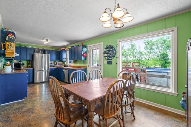dining space with baseboards, ornamental molding, a textured ceiling, and a notable chandelier