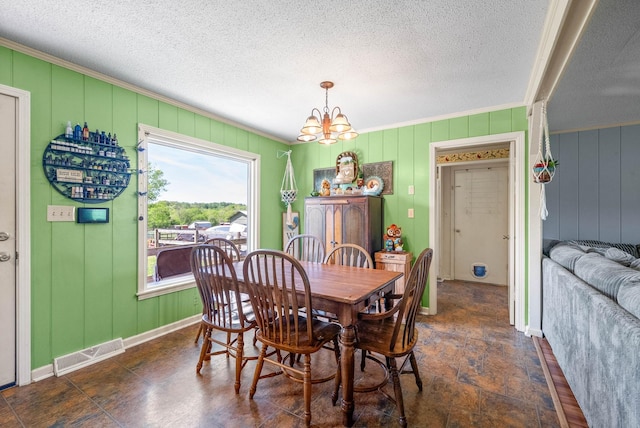 dining space featuring visible vents, a textured ceiling, crown molding, and an inviting chandelier