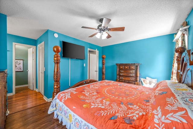 bedroom featuring a textured ceiling, baseboards, a closet, and wood finished floors