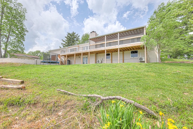 411 Willow Lake Dr, Portland, TN 37148 - back of house with a deck, a chimney, brick siding, a trampoline, and a yard