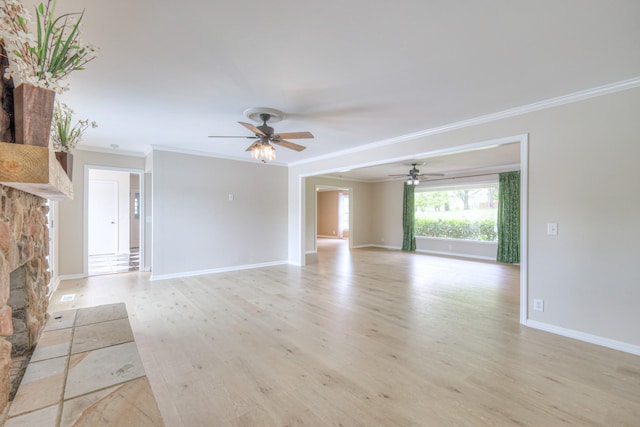 411 Willow Lake Dr, Portland, TN 37148 - unfurnished living room with crown molding, light wood finished floors, a stone fireplace, a ceiling fan, and baseboards